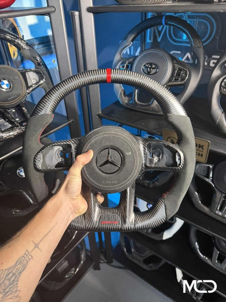 Black alcantara, Gloss carbon, Red stitching Mercedes AMG steering wheel by Miami Carbon Designs