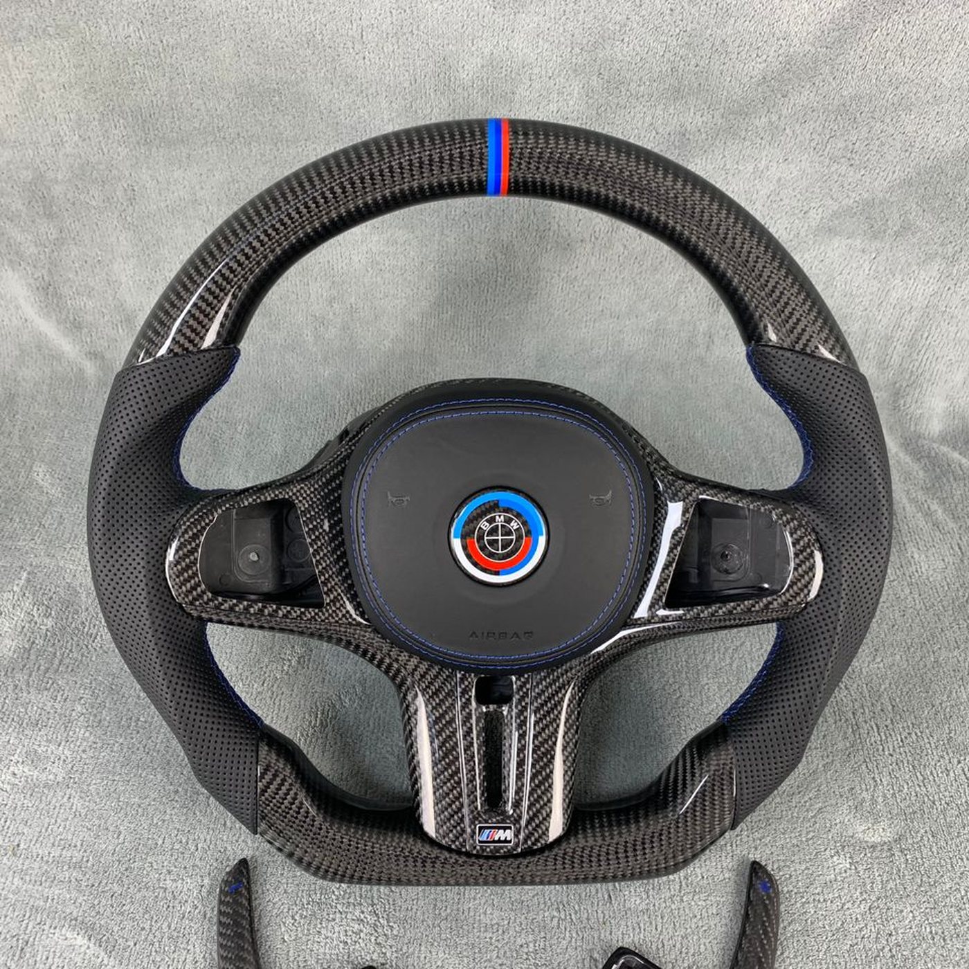 BMW G series custom gloss carbon fiber steering wheel with black perforated leather, M tricolor stripe and blue stitching by Miami Carbon Designs