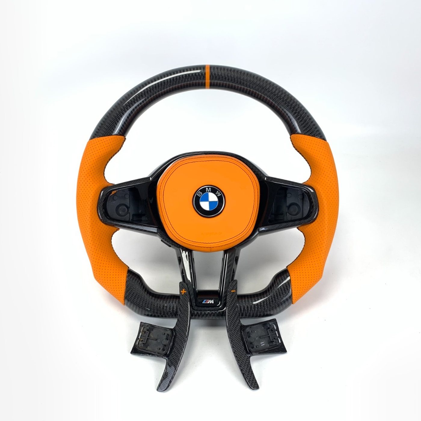 BMW G series custom gloss carbon fiber steering wheel in orange perforated leather with orange centerline and carbon paddles by Miami Carbon Designs