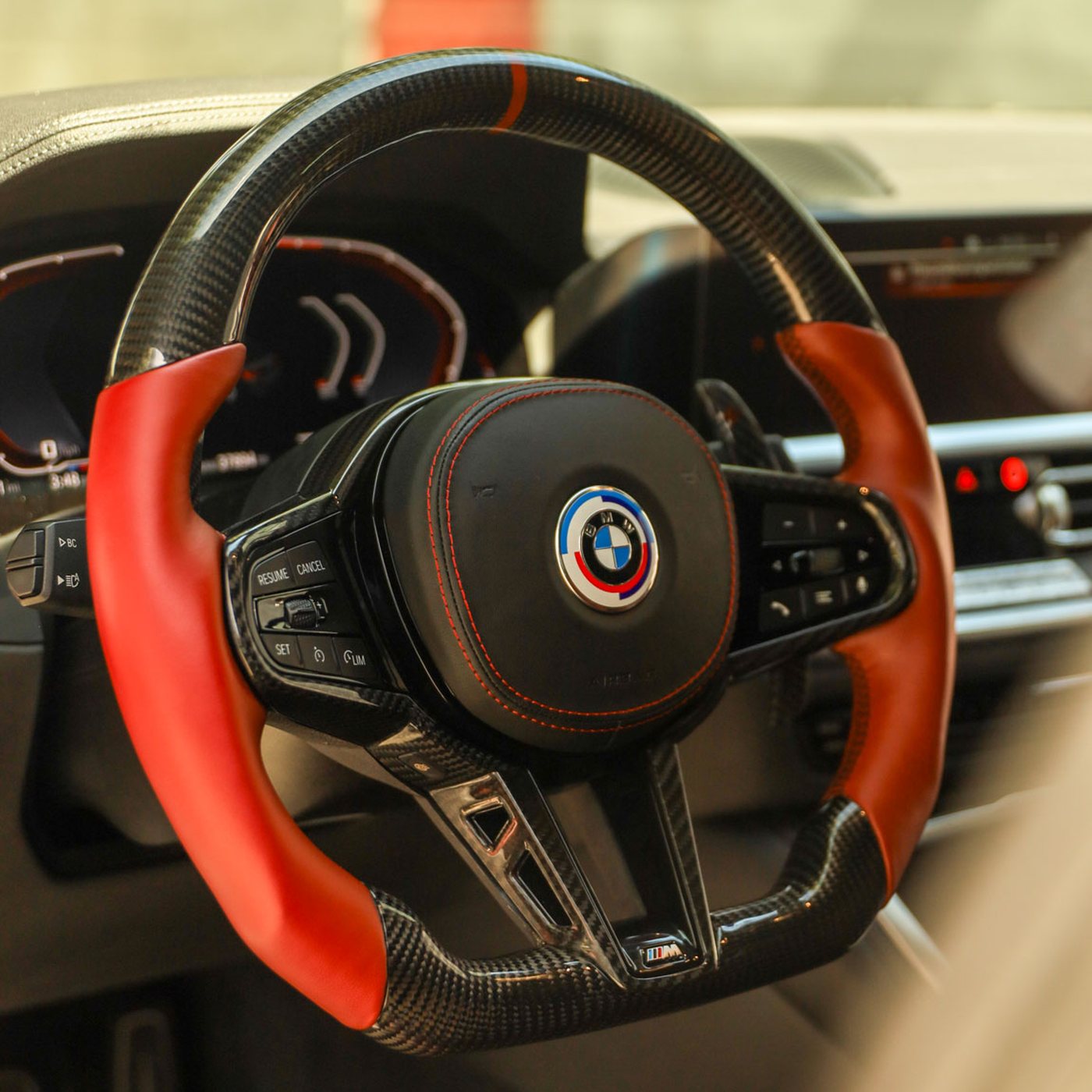 BMW G series custom carbon fiber steering wheel in red leather with red stitching and 50 year M badge, installed, by Miami Carbon Designs