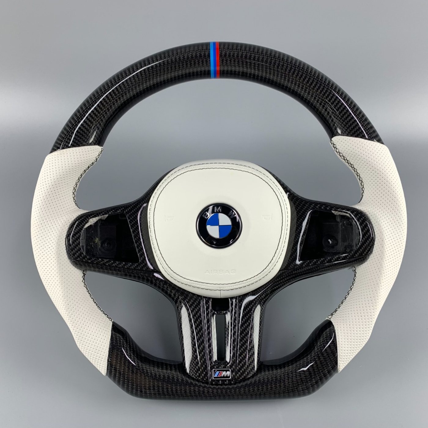 BMW G series custom gloss carbon fiber steering wheel with white perforated leather and M tricolor stripe by Miami Carbon Designs
