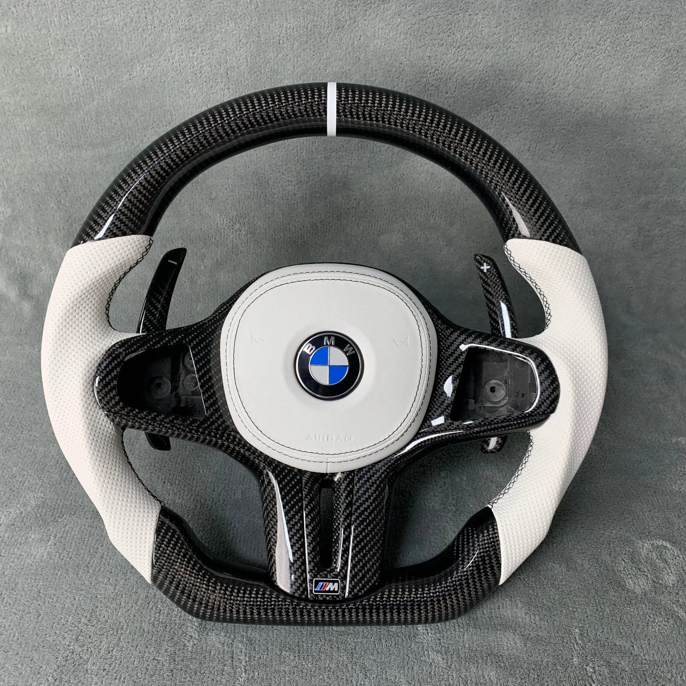 BMW G series custom gloss carbon fiber steering wheel with white perforated leather, white centerline and carbon paddles by Miami Carbon Designs