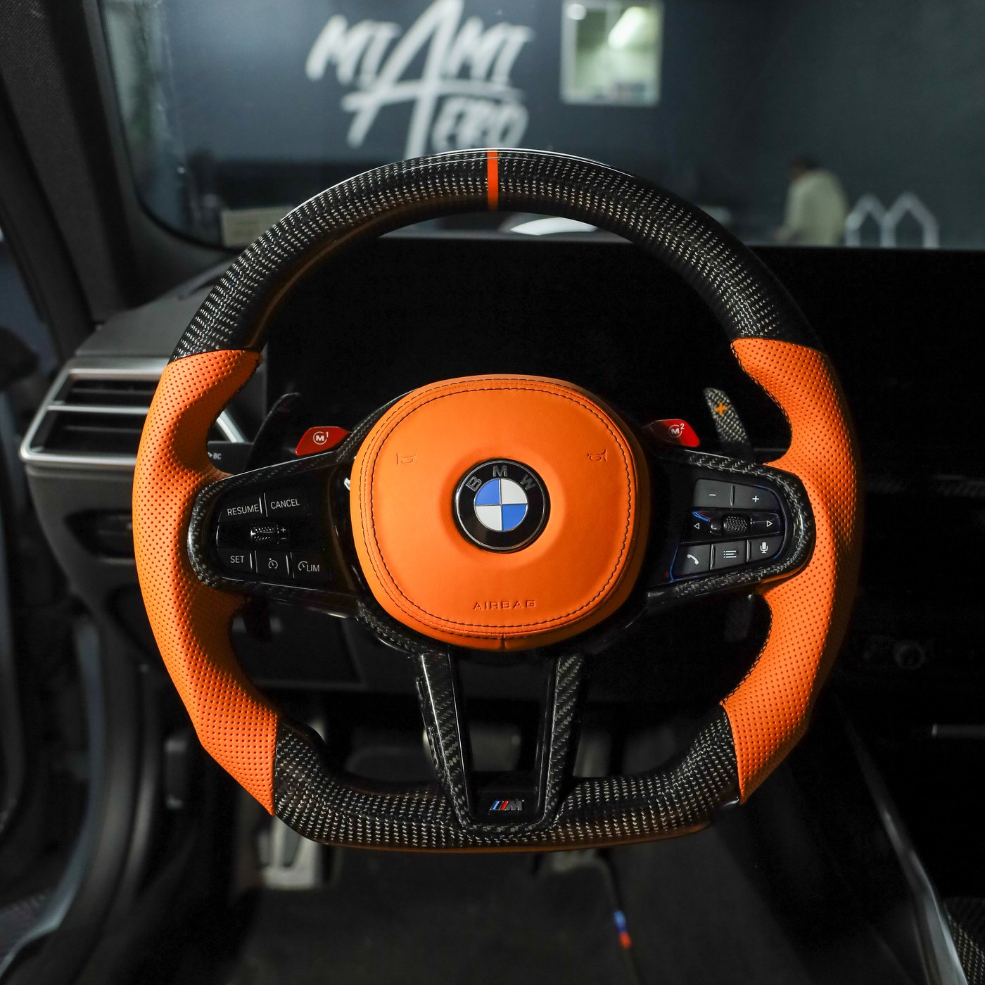 BMW G80 M3 custom carbon fiber steering wheel in orange perforated leather with orange centerline, installed, by Miami Carbon Designs