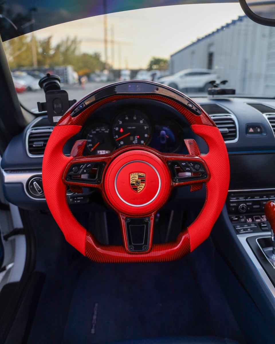 Custom carbon fiber steering wheel in red leather installed in a Porsche
