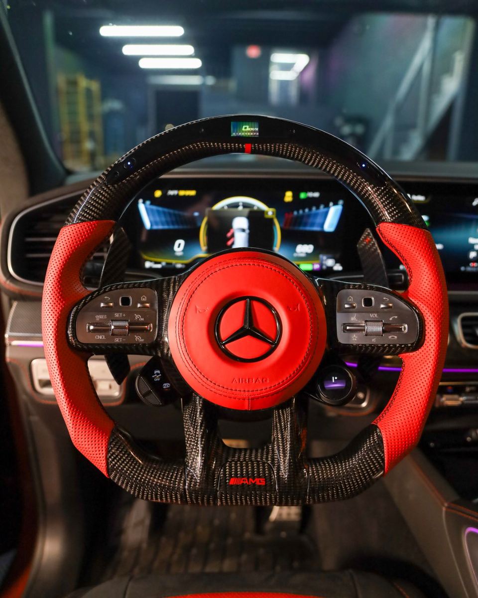 Custom carbon fiber steering wheel in red perforated leather installed in a Mercedes AMG
