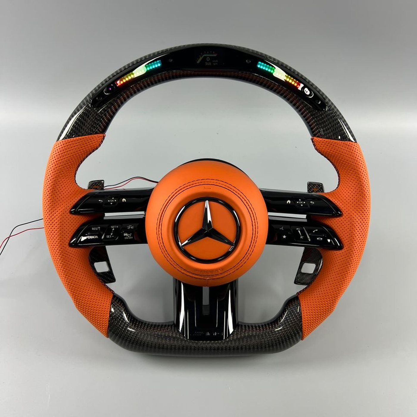 Mercedes AMG 2024 custom gloss carbon fiber steering wheel in orange perforated leather with LED display and orange airbag cover by Miami Carbon Designs