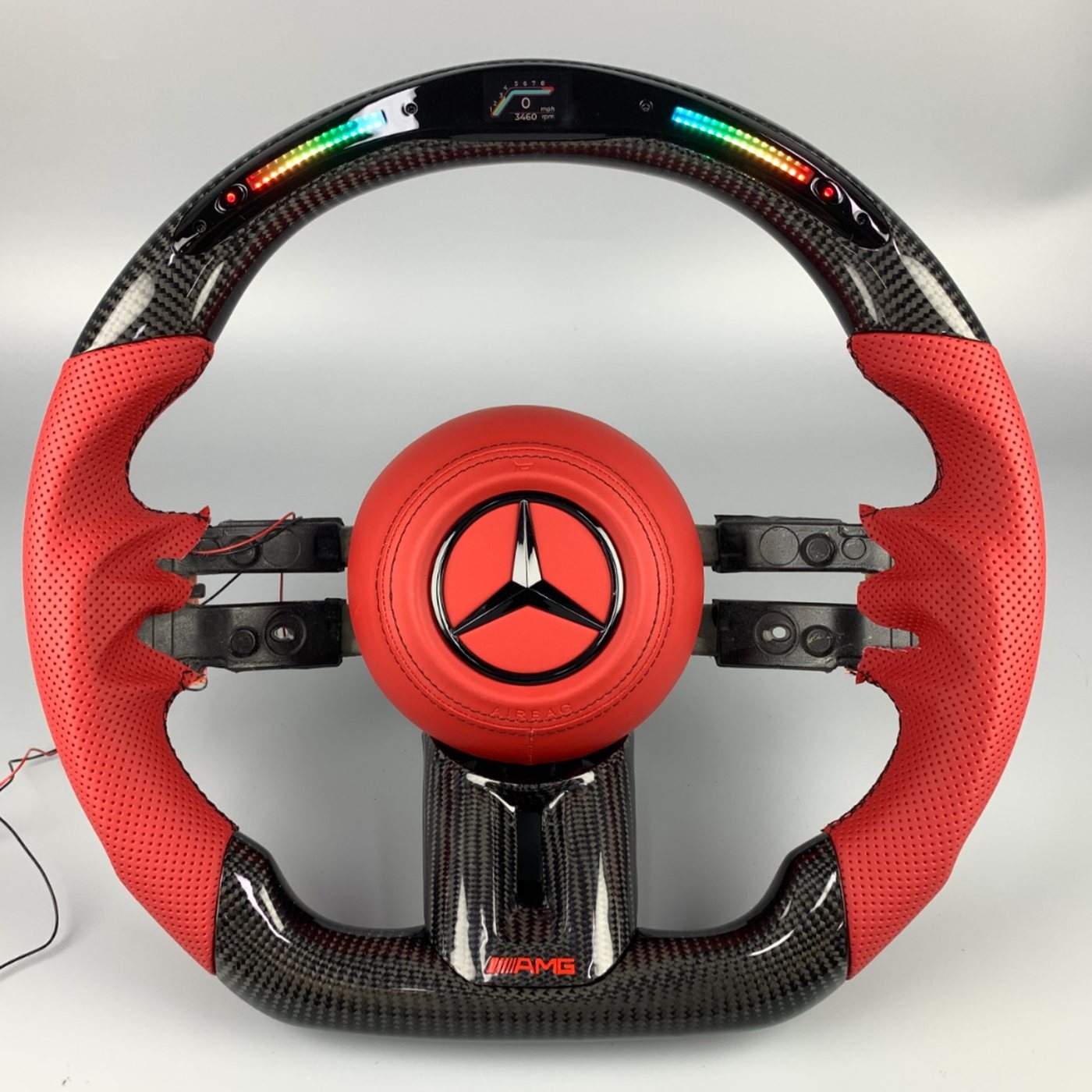 Mercedes AMG 2024 custom gloss carbon fiber steering wheel in red perforated leather with LED display and red AMG badge by Miami Carbon Designs