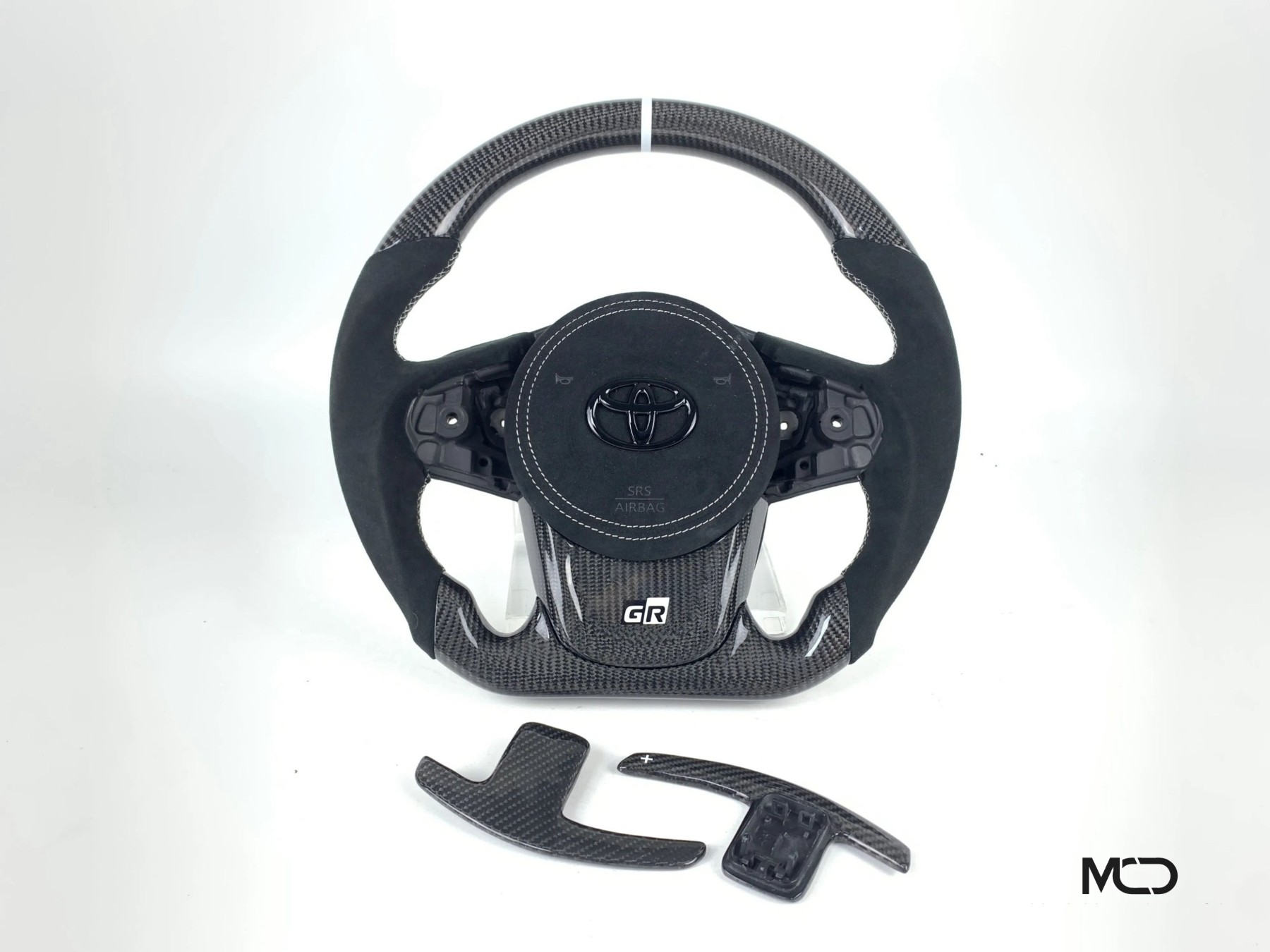 Toyota GR Supra custom carbon fiber steering wheel, black Alcantara, white stitching, white stripe, Alcantara airbag cover, carbon paddle shifters