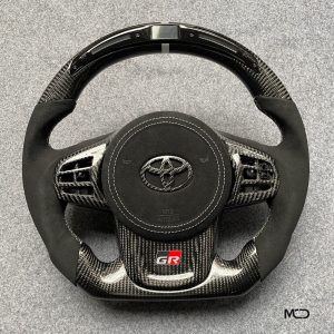 Toyota GR Supra custom carbon fiber steering wheel, black Alcantara, white stitching, white stripe, Alcantara airbag cover, LED shift light
