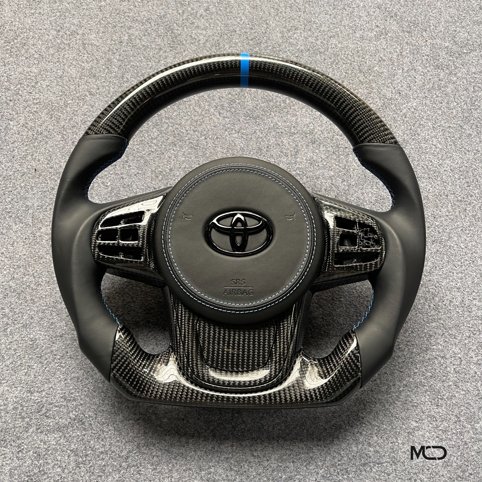 Toyota GR Supra custom carbon fiber steering wheel, black leather, blue stitching, blue stripe, leather airbag cover, gloss carbon